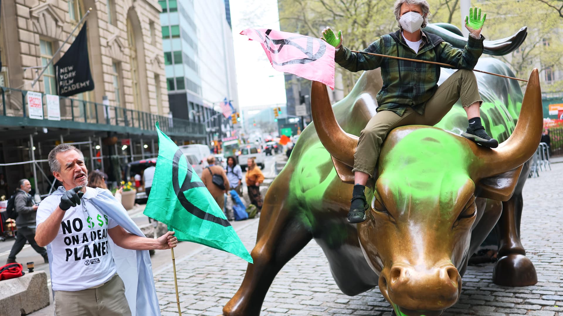 Wall Street's iconic charging bull statue vandalized by climate activists wielding neon green paint