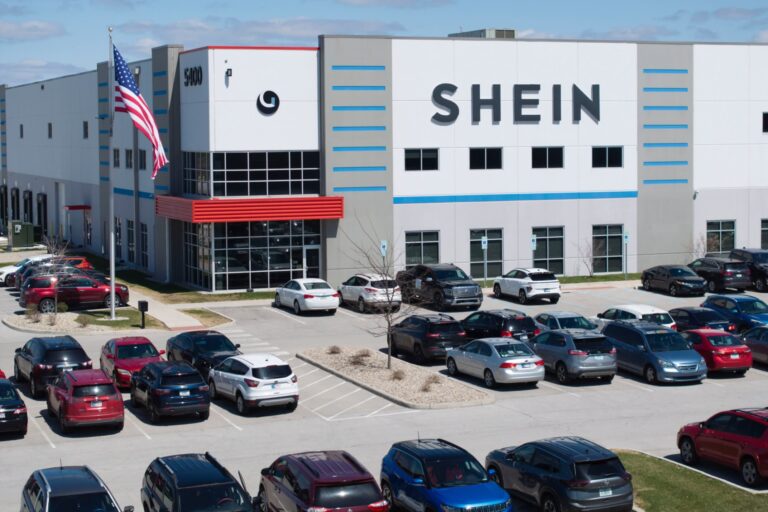 Cars are parked in front of the building, which has a large “Shein” sign on it