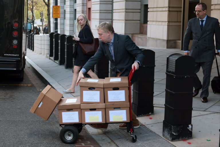 A man pushes a hand truck loaded with boxes labeled “Federal Trade Commission v. Meta Platforms, Inc.” outside the E. Barrett Prettyman United States Court House in Washington DC.