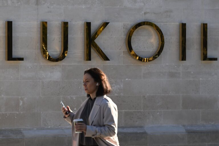 A woman walks past the headquarters of Russia’s oil producer Lukoil in Moscow