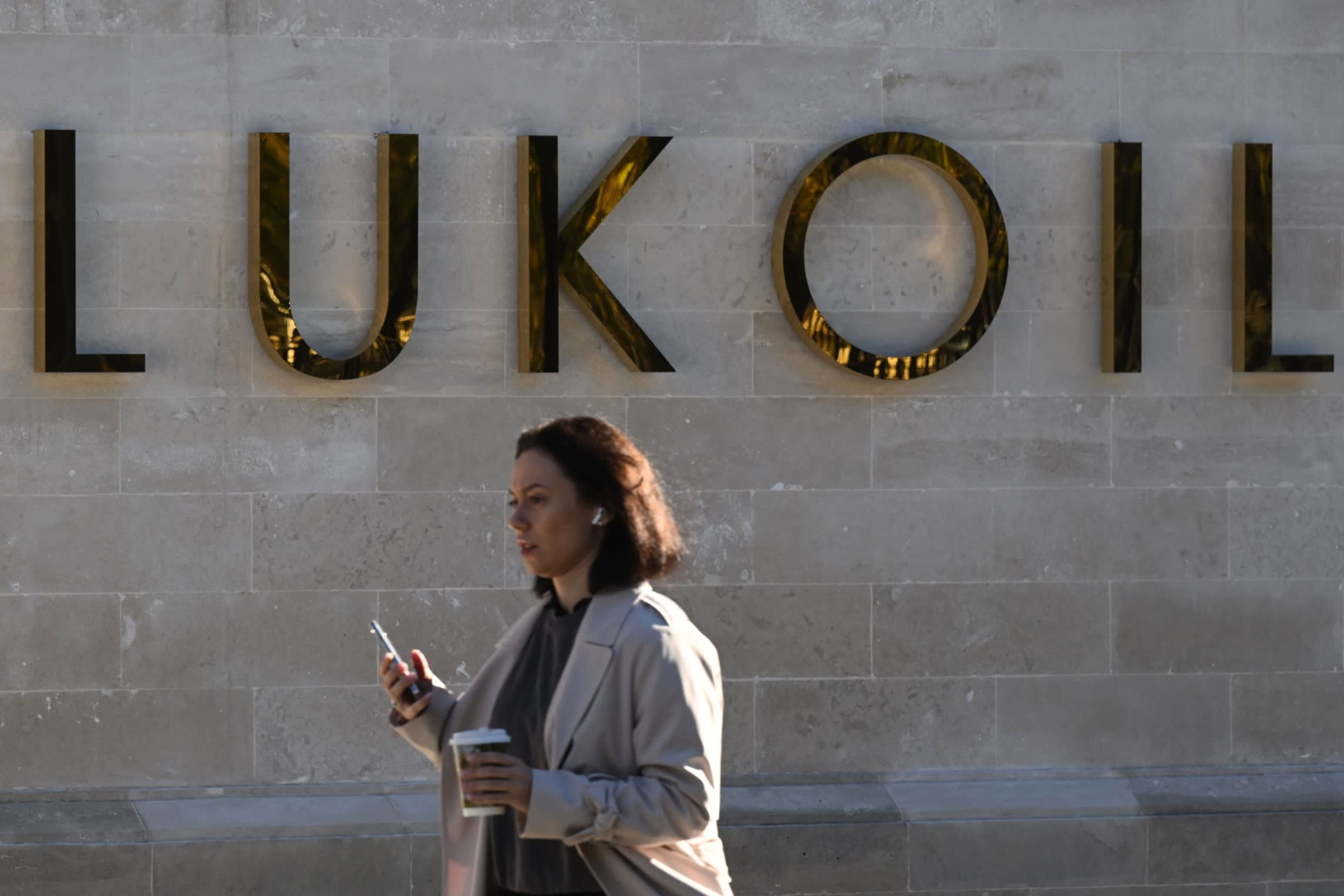 A woman walks past the headquarters of Russia’s oil producer Lukoil in Moscow