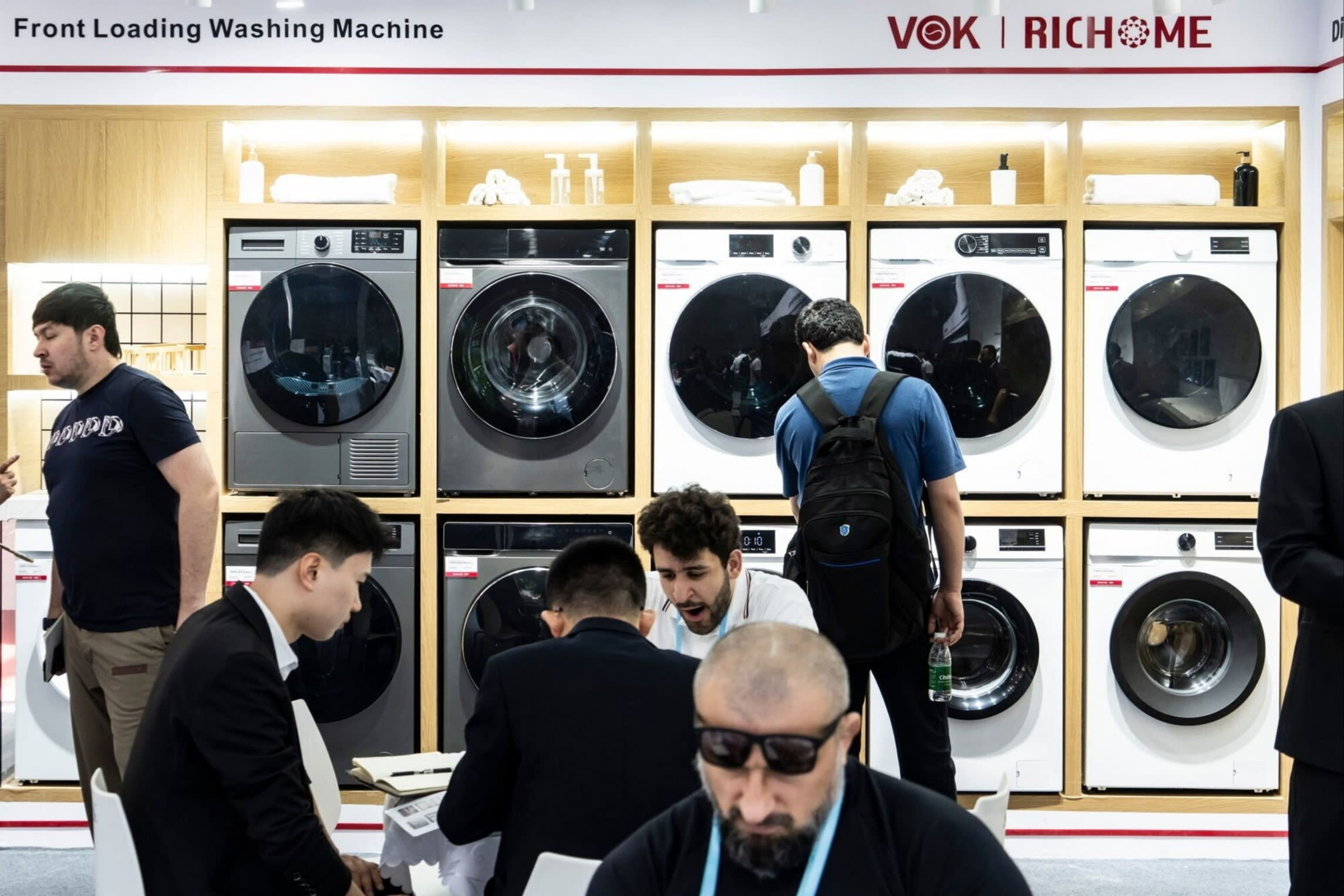 Attendees look at front loading washing machines on display