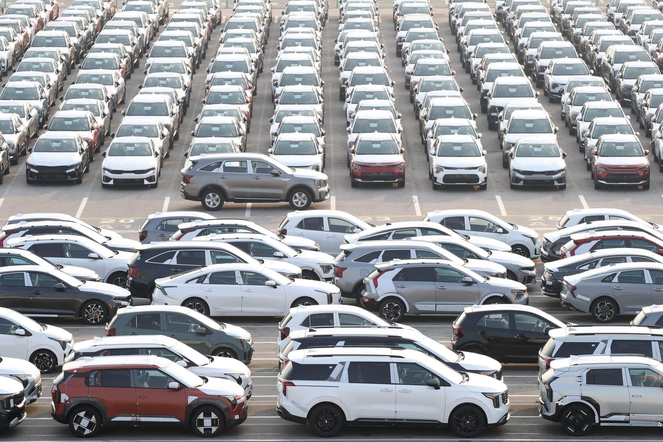 Vehicles produced by South Korean automaker Kia Motors are lined up ready to be shipped at the company’s shipping yard at the Port of Pyeongtaek