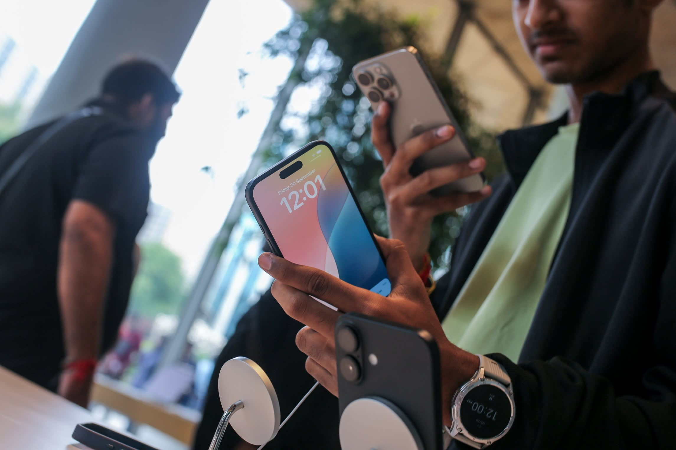 A customer looks at an Apple iPhone 16 at the Apple BKC store in Mumbai, India