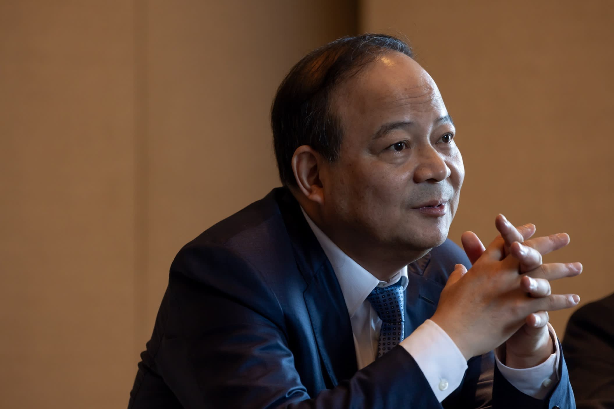 Robin Zeng clasping his hands in a room in Hong Kong on May 20 2025