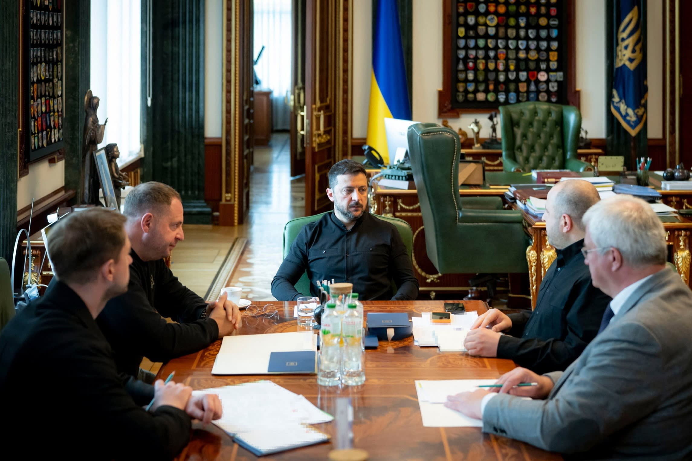Volodymyr Zelenskyy meets with Ukraine officials at a table