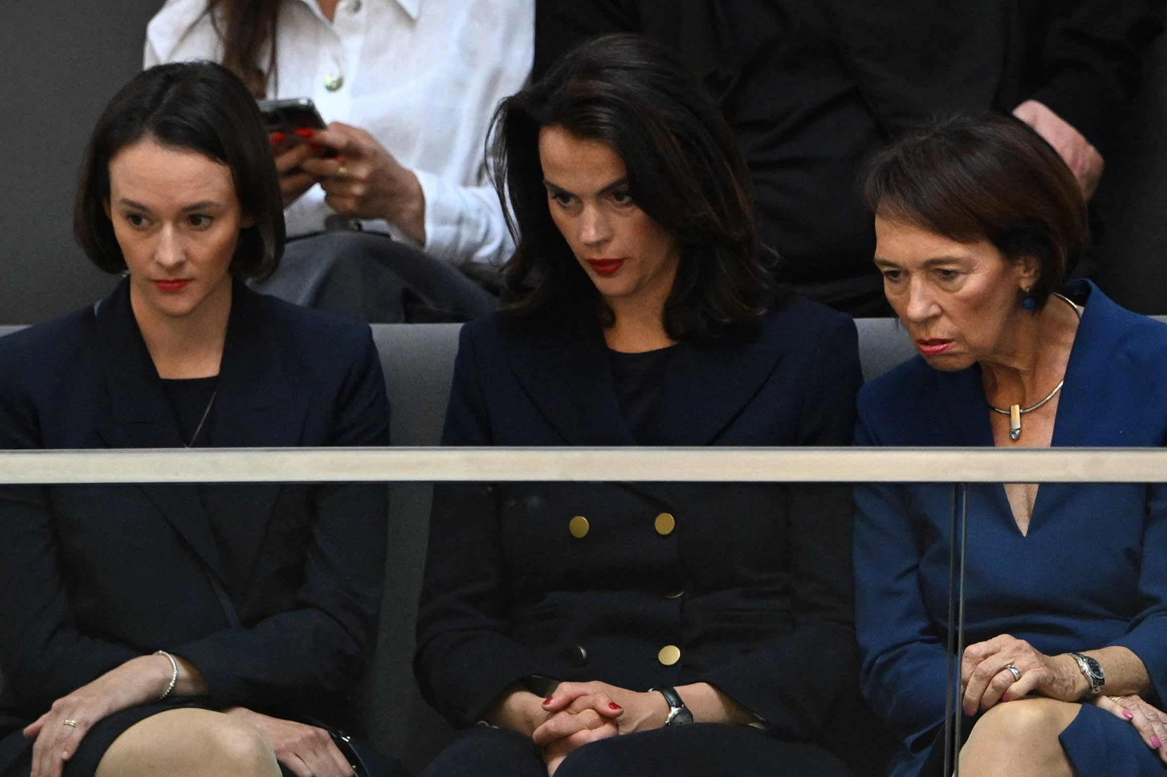 Charlotte Merz (R), wife of Designated German Chancellor Friedrich Merz looks on next to her daughters Carola Cluesener (L) and Constanze Merz prior a second round of voting during a session at the Bundestag