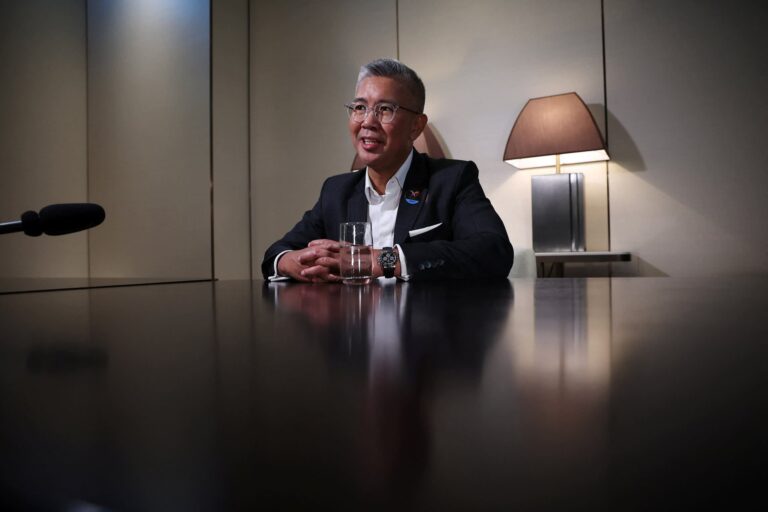 Aziz sitting at a highly polished table