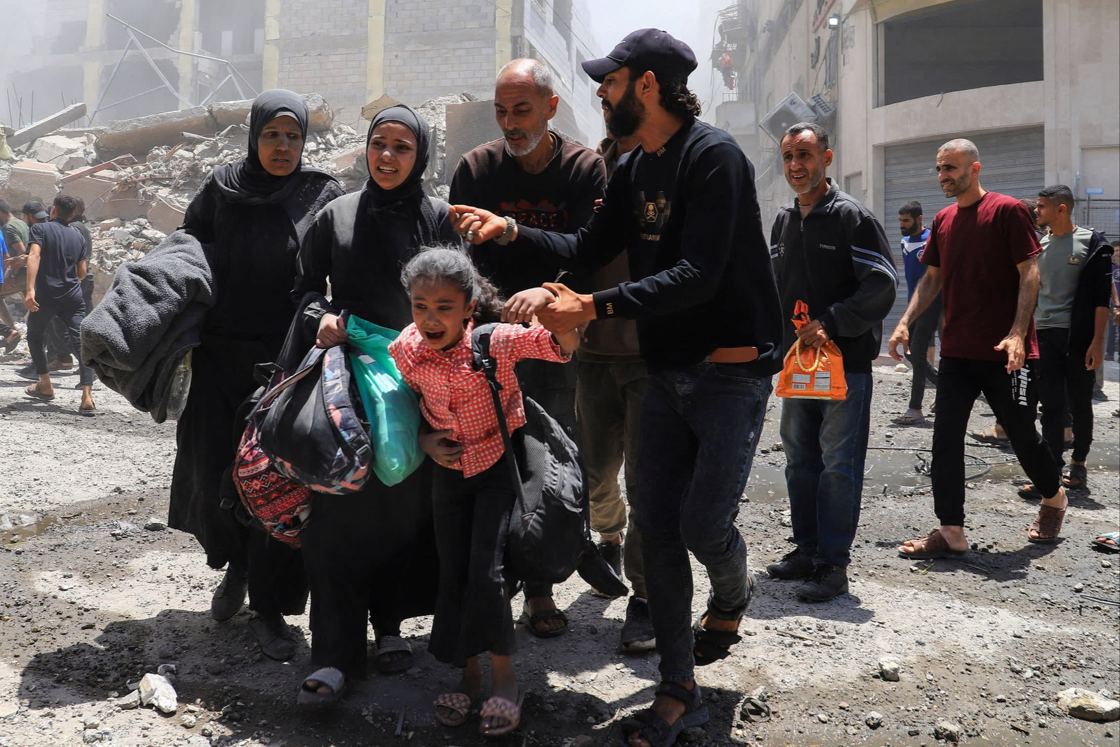 Palestinians evacuate in the aftermath of an Israeli strike on a house, in Gaza City on Friday
