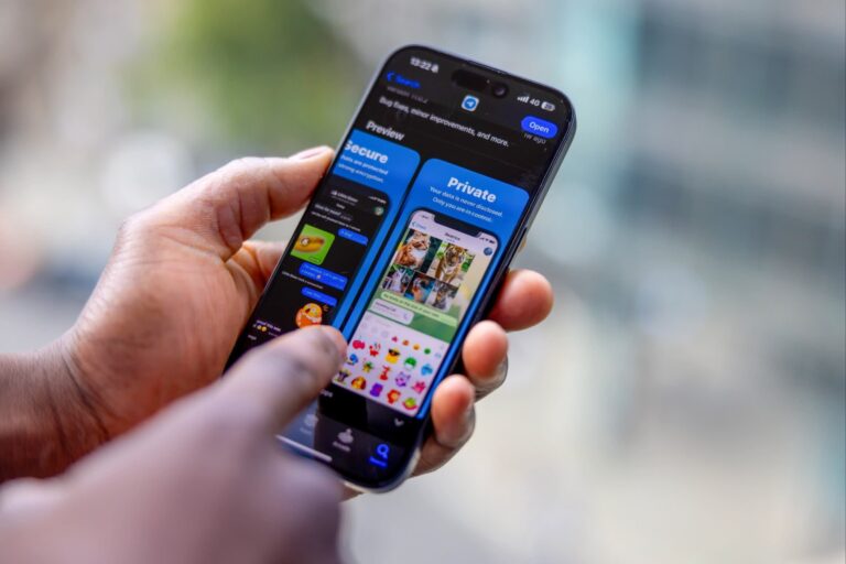 A finger hovers over Telegram app on a phone being held