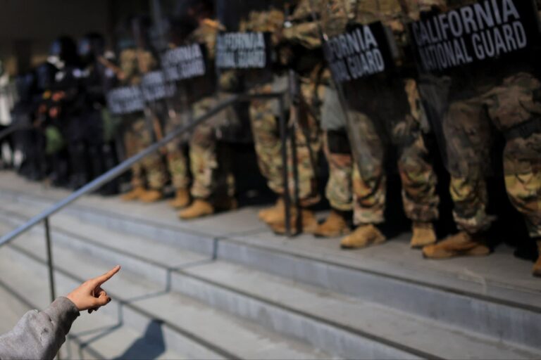 A protester points towards California National Guard troops in Los Angeles, California on June 9 2025