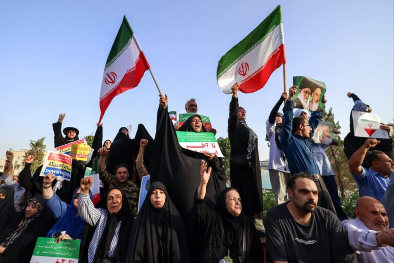 Iranians chant slogans and wave national flags as they celebrate a ceasefire between Iran and Israel in Tehran on Tuesday