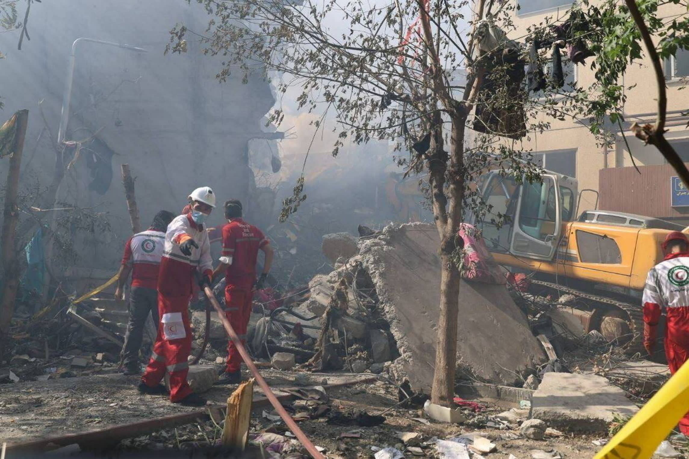 Rescue teams working outside a building that was struck by an Israeli air strike in Tehran on June 14 2025