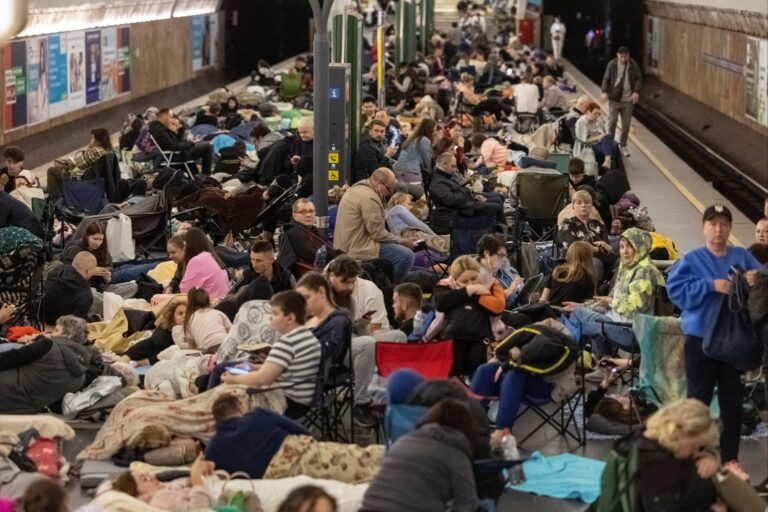 People take shelter inside a metro station during a Russian military strike