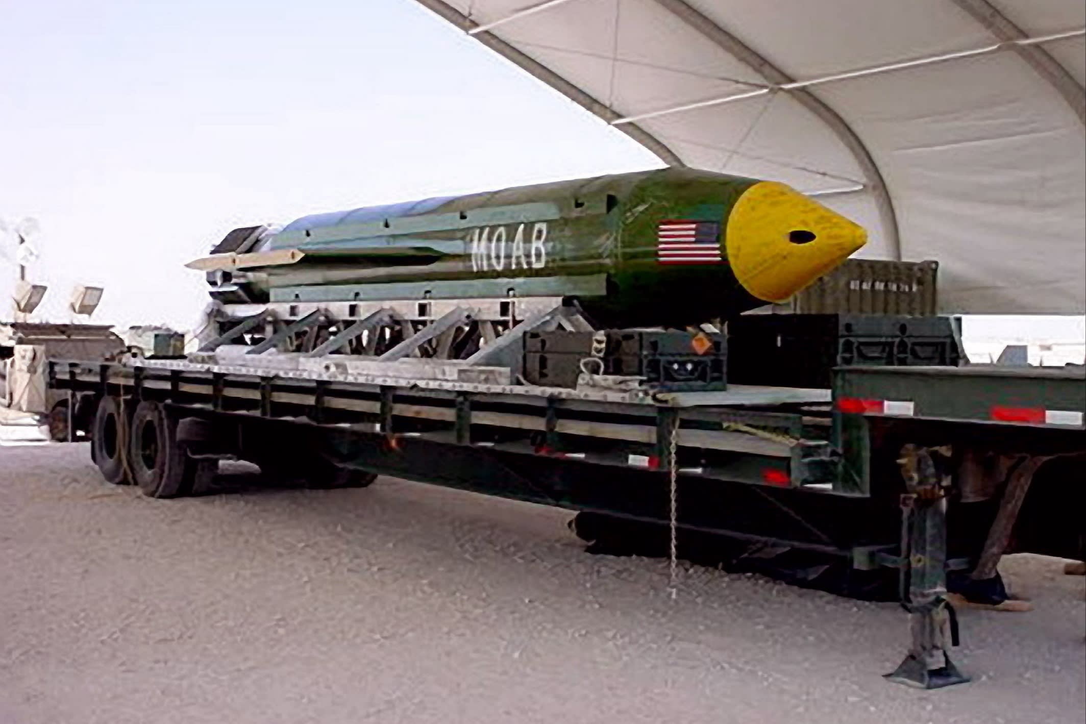 The bomb has a US flag on its side and is lying on a trailer
