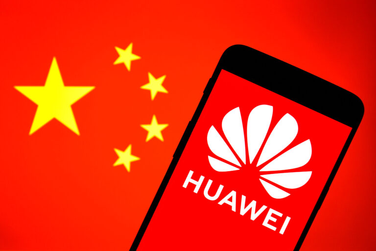 In this photo illustration a Huawei logo is displayed on a smartphone with a Chinese flag in the background.