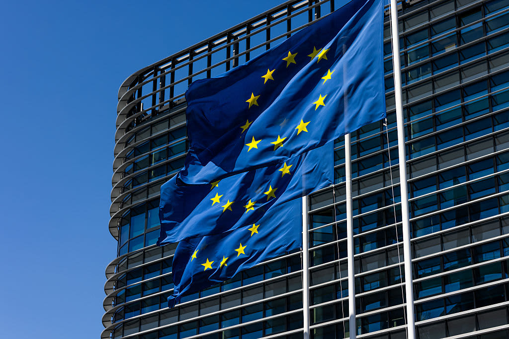 The flags of the European Union fly in front of the European Parliament.