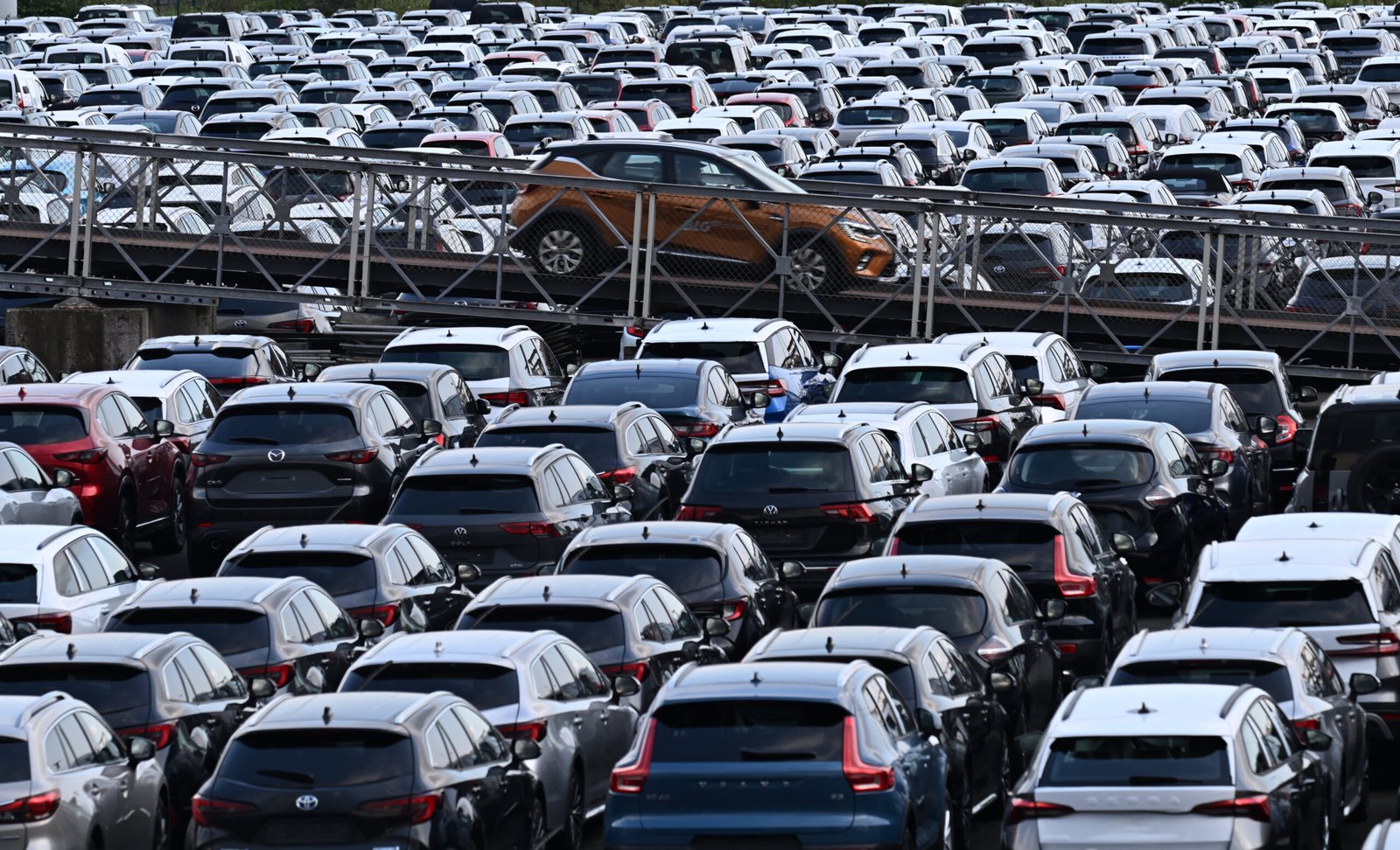 New cars of various brands are parked for export on the parking of a car terminal at the harbour of Duisburg, western Germany, on August 7, 2024.